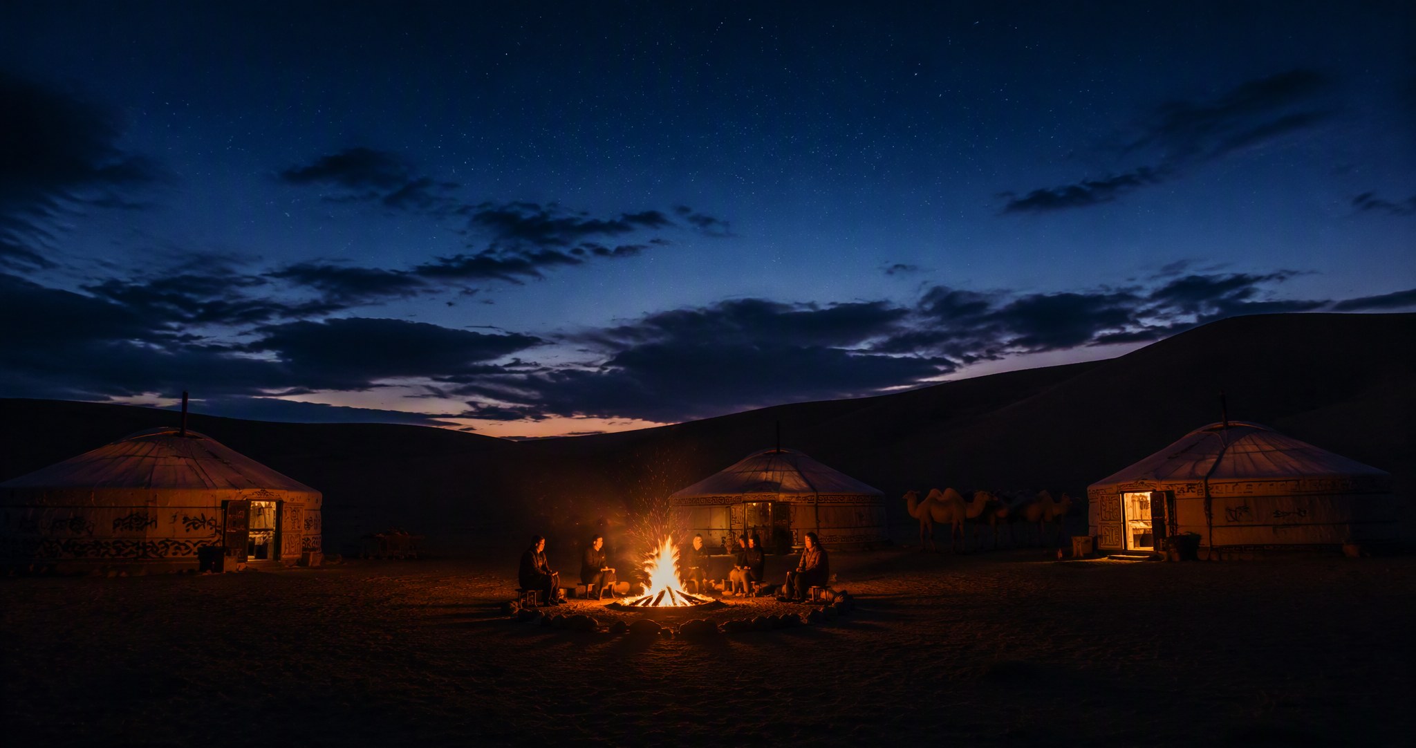 Yurt camp with a bonfire under the desert night sky
